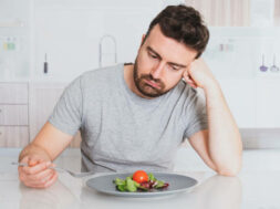 Worried man hungry and starved with salad