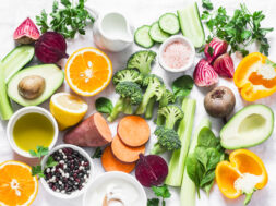 Five best vitamins for beautiful skin. Products with vitamins A, B, C, E, K – broccoli, sweet potatoes, orange, avocado, spinach, peppers, olive oil, dairy, beets, cucumber, beens. Flat lay, top view