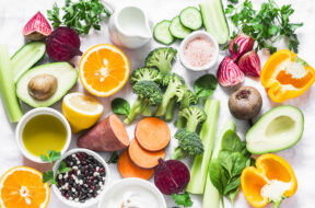 Five best vitamins for beautiful skin. Products with vitamins A, B, C, E, K – broccoli, sweet potatoes, orange, avocado, spinach, peppers, olive oil, dairy, beets, cucumber, beens. Flat lay, top view