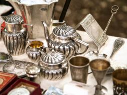Antique silver teapots, creamer and other utensils at a flea market