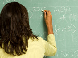 Female student writing on blackboard