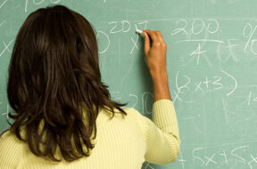 Female student writing on blackboard