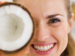 Happy,Young,Woman,Holding,Coconut,Piece,In,Front,Of,Eye