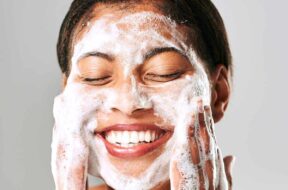 A-beautiful-young-woman-washing-her-face-with-facial-cleanser