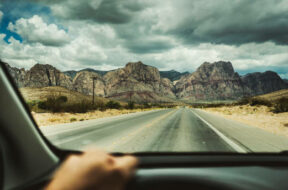 Driving a car on desert highway POV